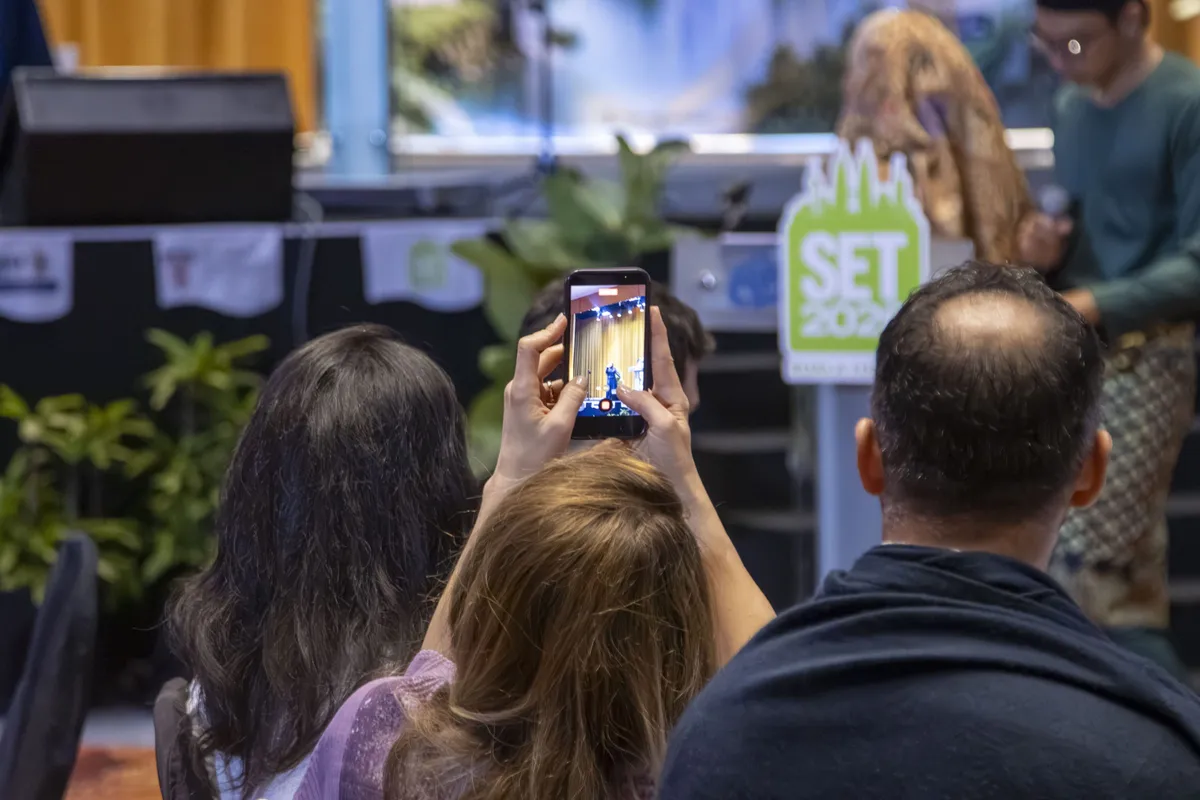 A member photographing the stage at SET2026